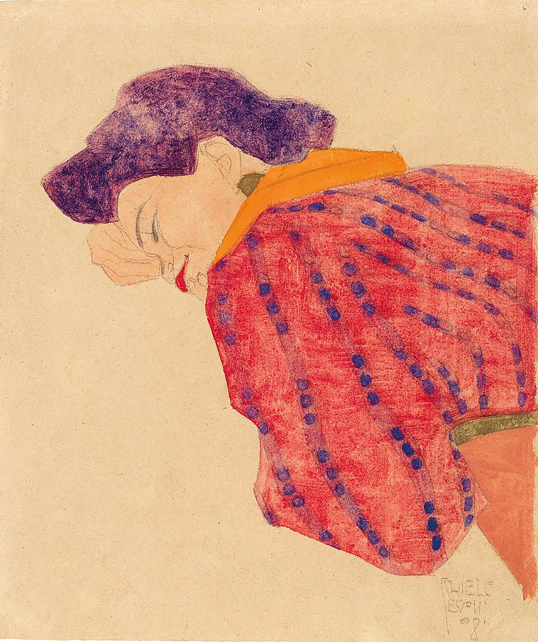Woman in red blouse lying on her front, one hand covering her nose
